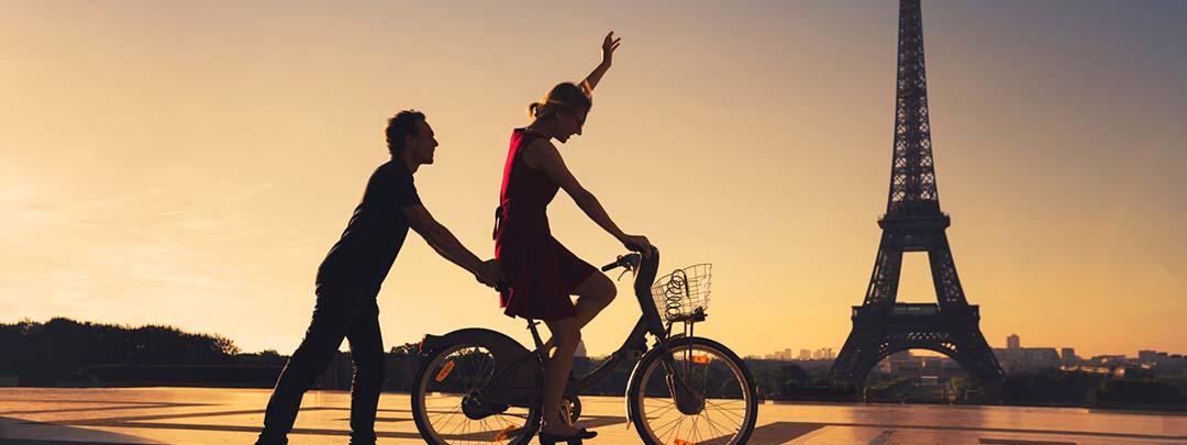 happy couple having fun in Paris riding bicycle near Eiffel tower